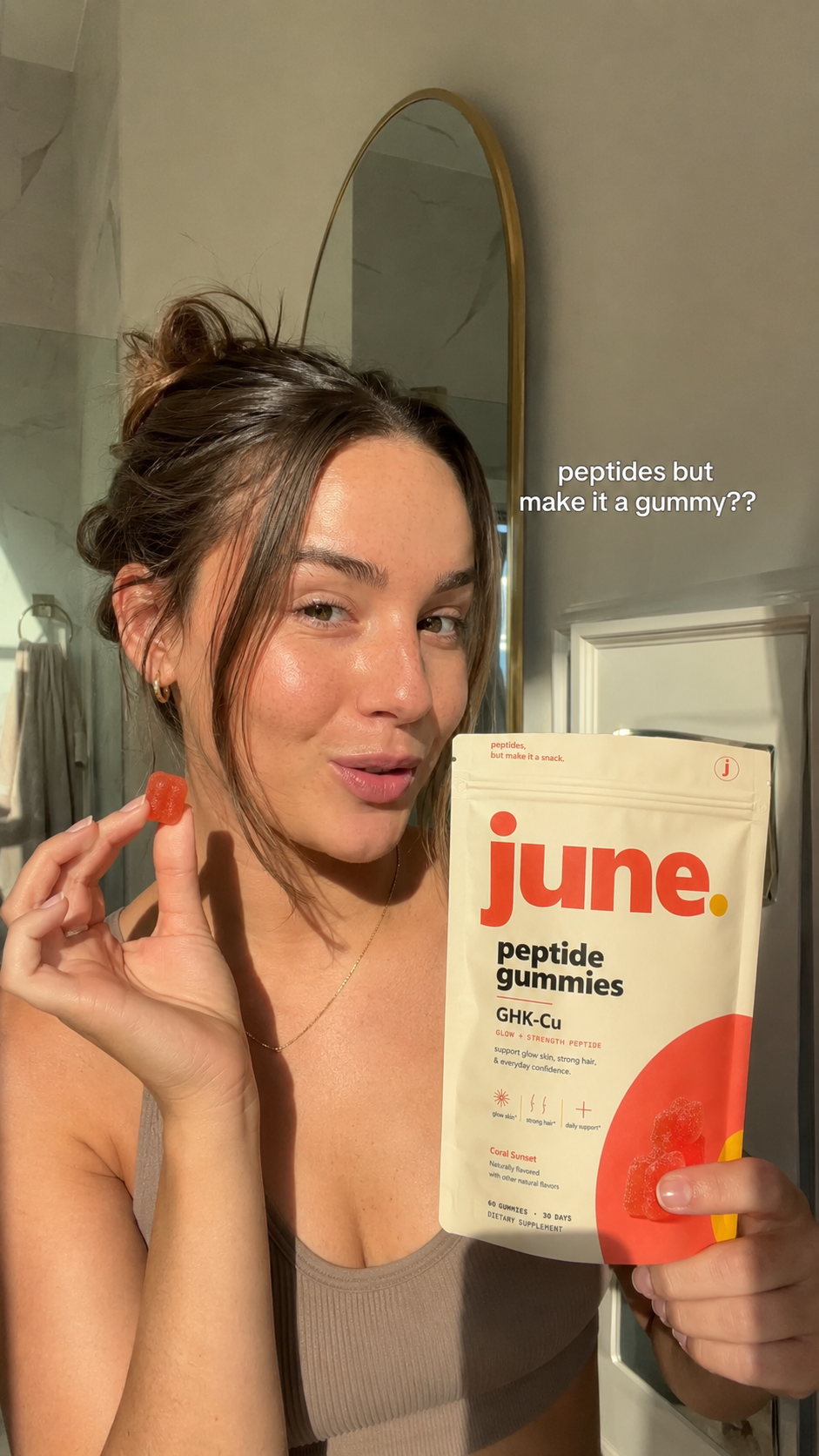 Creator holding June gummies in a mirror selfie
